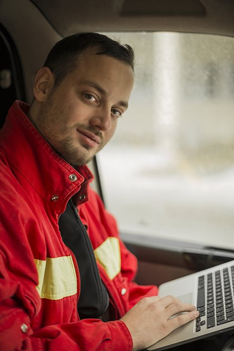 Feuerwehrmann im Fahrzeug mit Laptop