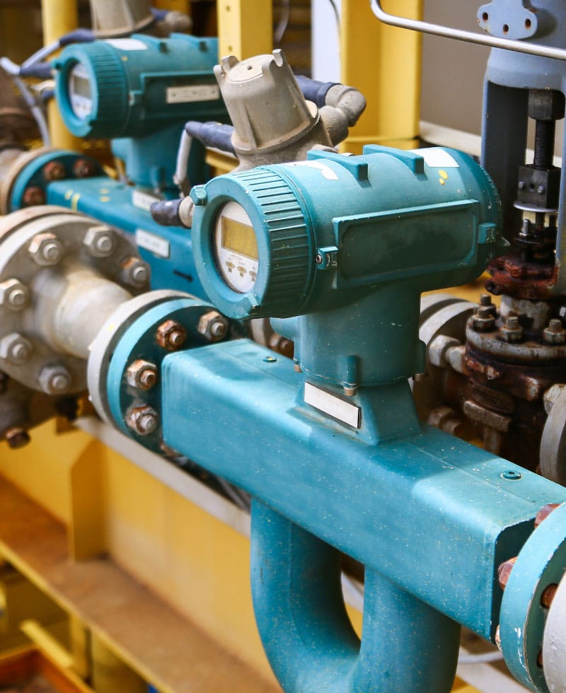 Durchflussmessgeräte, die an industriellen Rohrleitungen montiert sind.