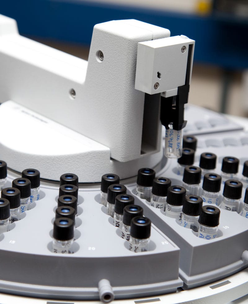 Nahaufnahme eines Gaschromatographie-Analysegeräts mit Probengläsern.